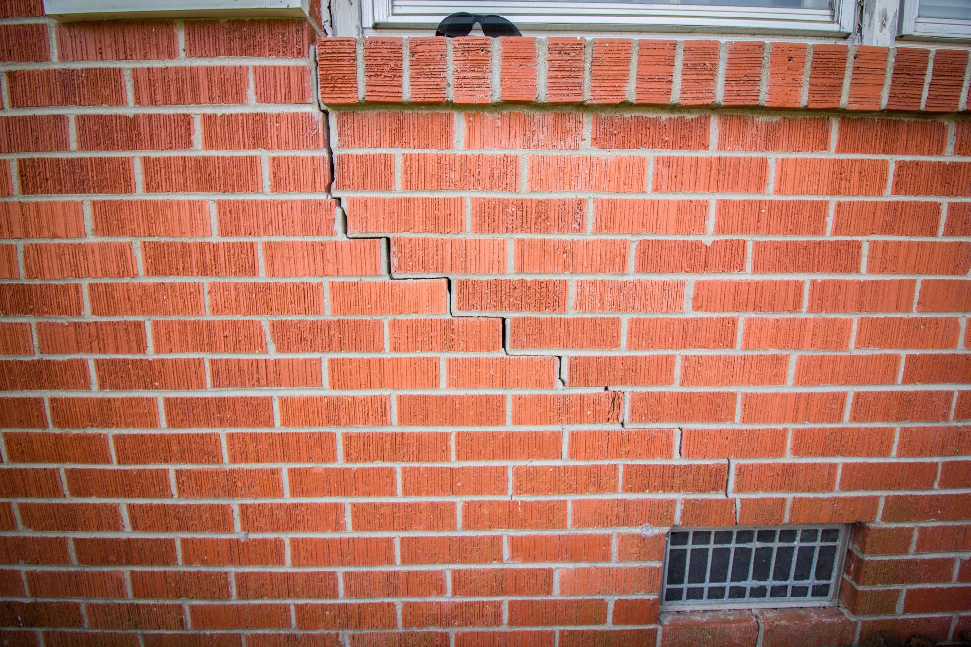 Staircase cracks in brickwork signifying foundation damage and a need for helical piles